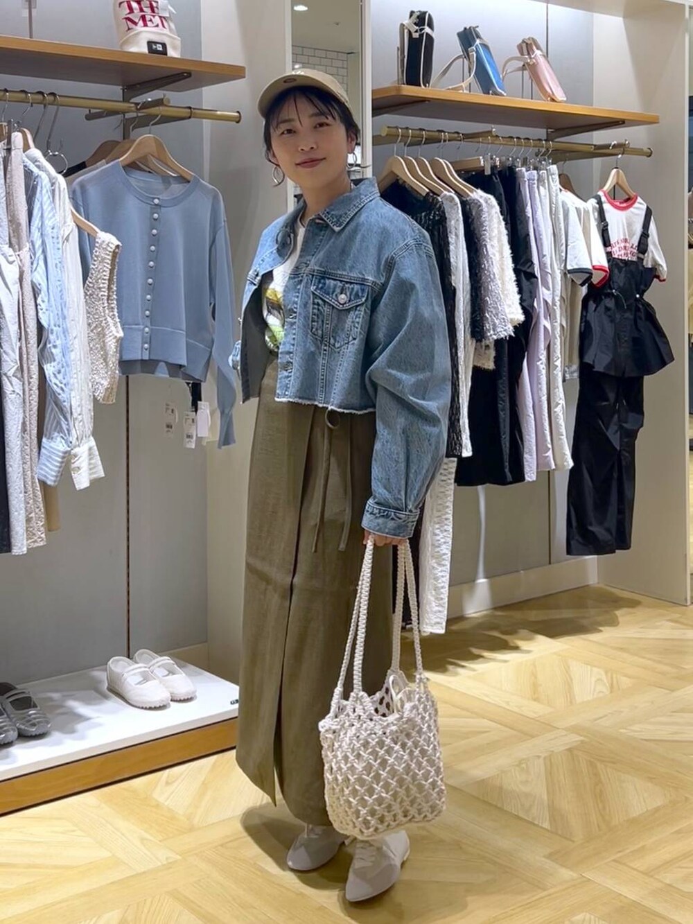 ブラウン系のスカート、ブルー系のデニムジャケット、ホワイト系のスニーカーを着用したレディースの春コーディネートの5枚目の写真