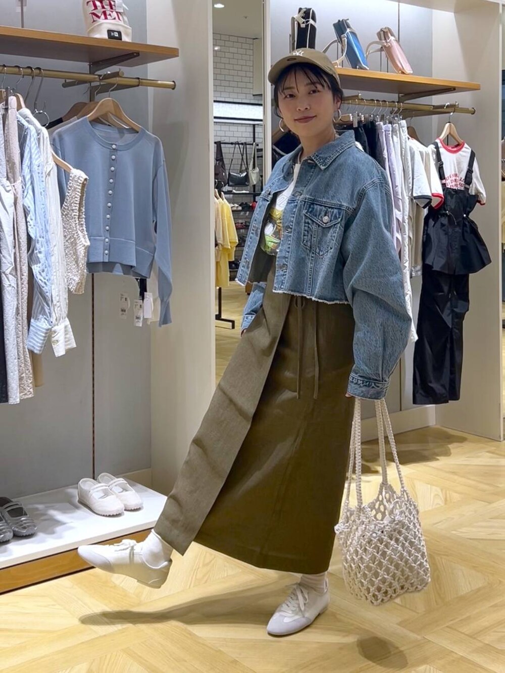 ブラウン系のスカート、ブルー系のデニムジャケット、ホワイト系のスニーカーを着用したレディースの春コーディネートの4枚目の写真