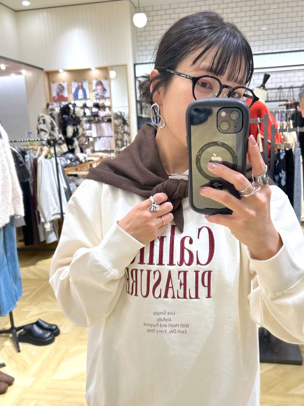 ブラウン系のスカート、ホワイト系のスウェット、ブラック系のローファーを着用したレディースの秋コーディネートの10枚目の写真