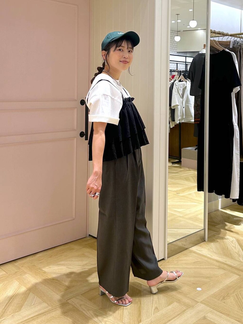 グレー系のスラックス、シルバー系のサンダル、ホワイト系のTシャツ/カットソーを着用したレディースの夏コーディネートの6枚目の写真