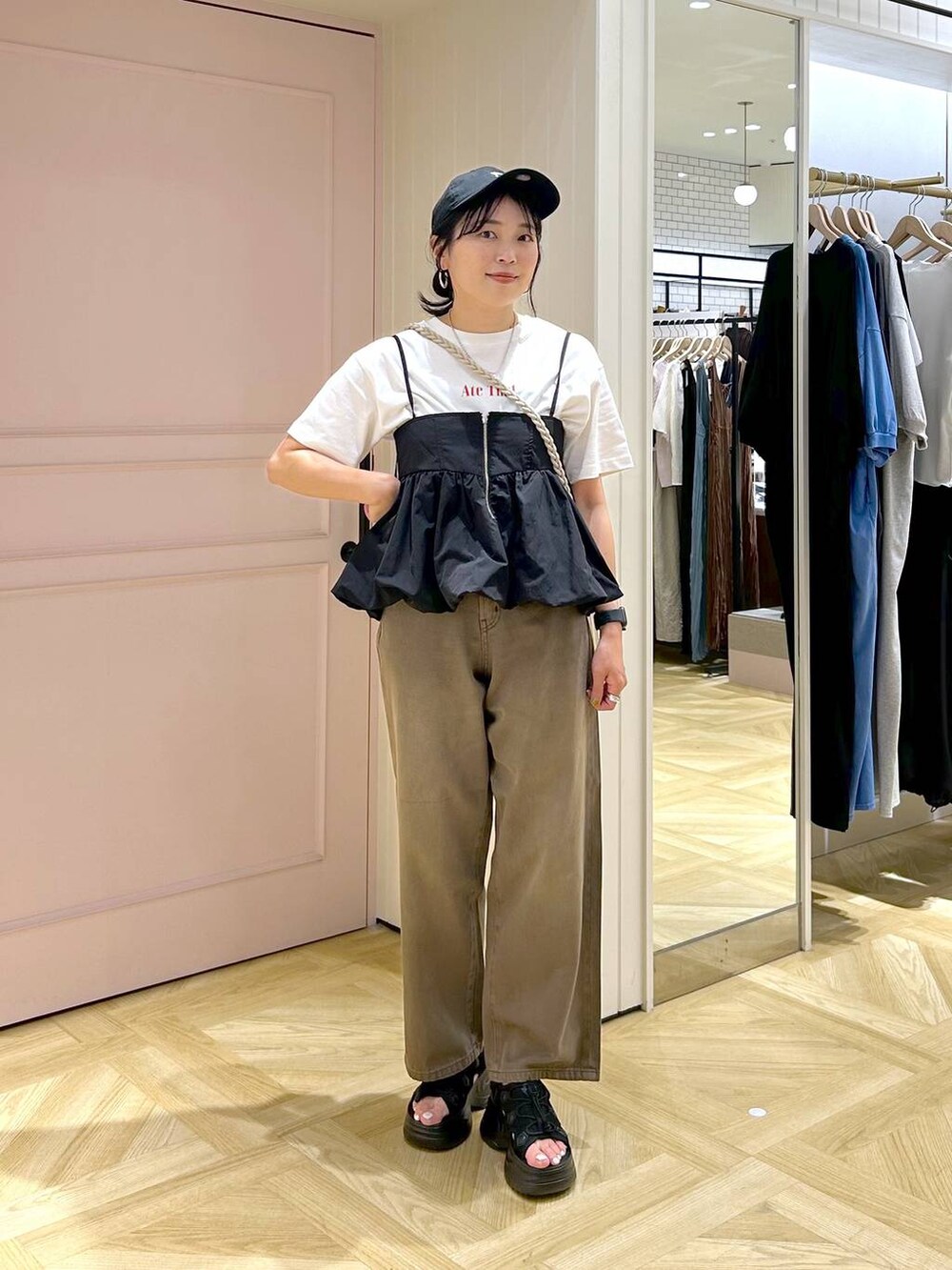 ブラック系のサンダル、ブラック系のキャミソール、ブラウン系のデニムパンツを着用したレディースの春コーディネートの5枚目の写真