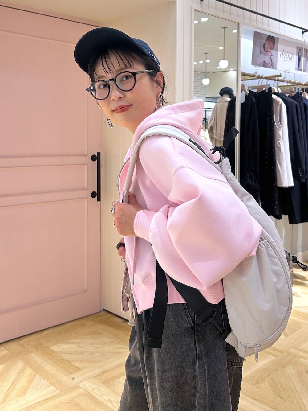 ピンク系のパーカー、ブラック系のデニムパンツ、グレー系のタンクトップを着用したレディースの春コーディネートの8枚目の写真