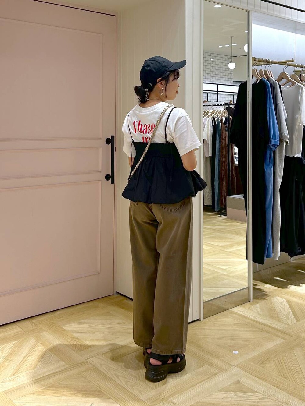 ブラック系のサンダル、ブラック系のキャミソール、ブラウン系のデニムパンツを着用したレディースの春コーディネートの4枚目の写真