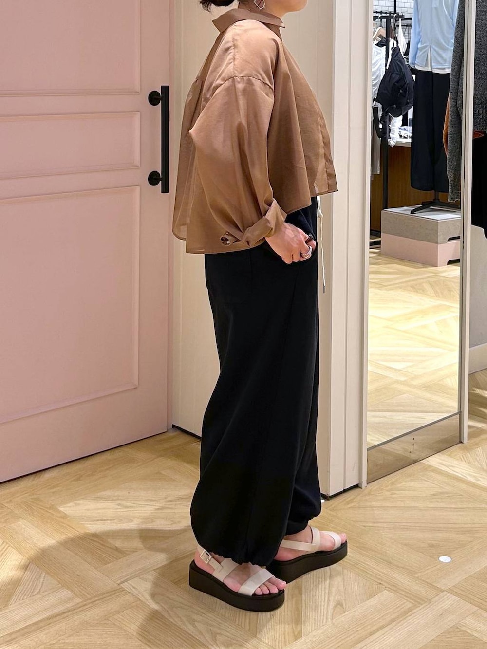 ブラウン系のシャツ/ブラウス、ホワイト系のサンダル、ブラック系のサロペット/オーバーオールを着用したレディースの春コーディネートの5枚目の写真