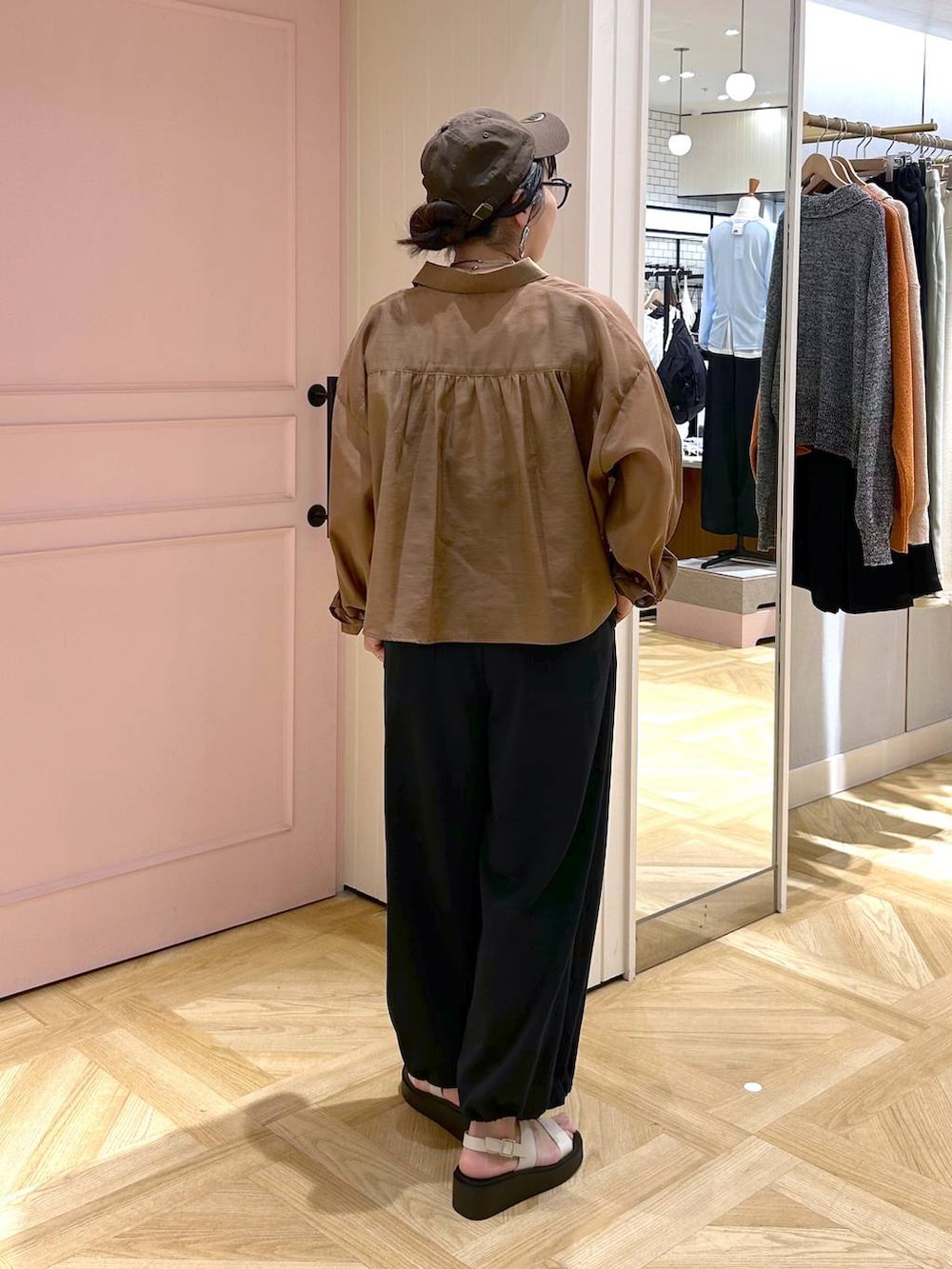 ブラウン系のシャツ/ブラウス、ホワイト系のサンダル、ブラック系のサロペット/オーバーオールを着用したレディースの春コーディネートの4枚目の写真