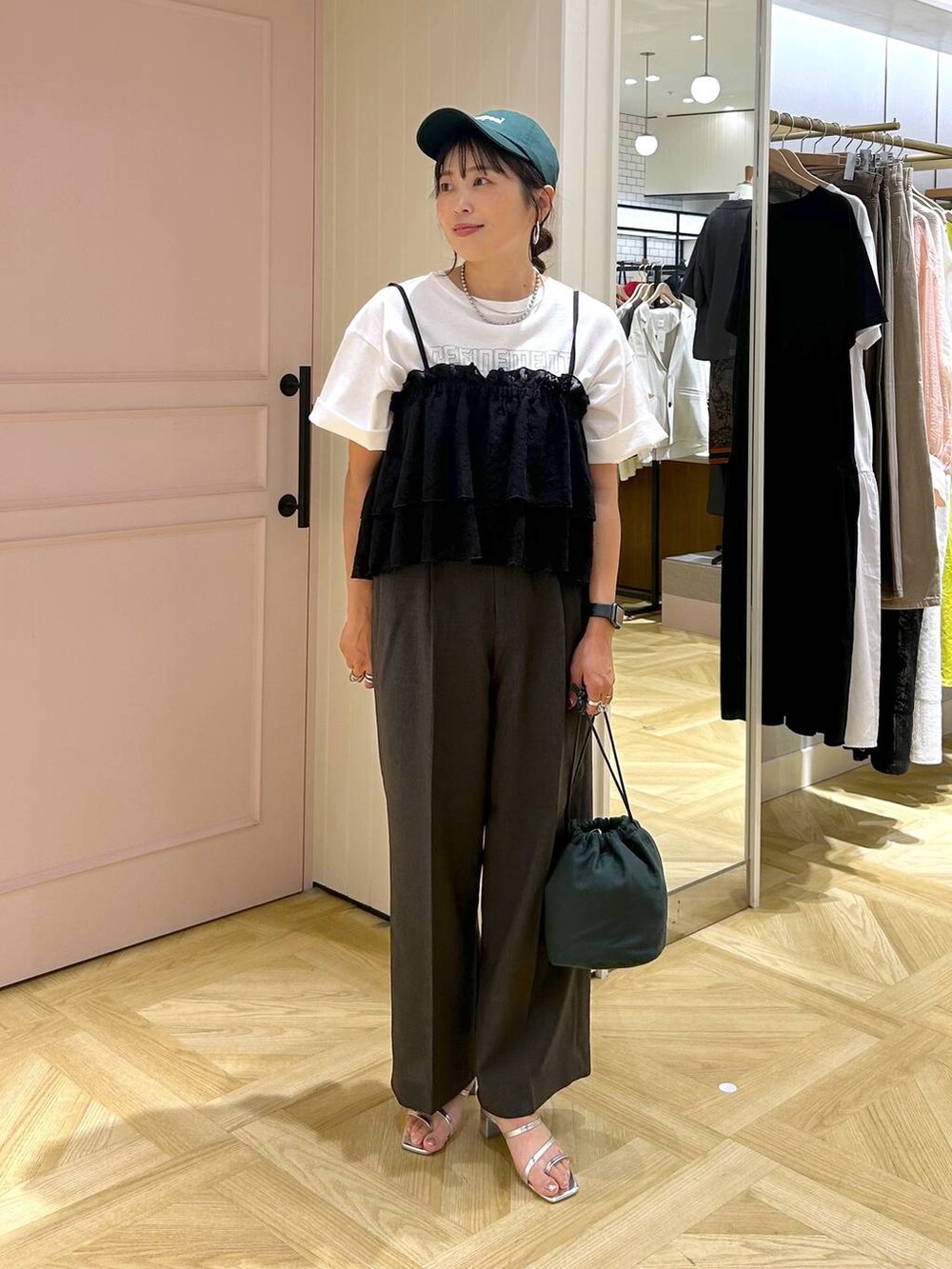 グレー系のスラックス、シルバー系のサンダル、ホワイト系のTシャツ/カットソーを着用したレディースの夏コーディネートの3枚目の写真