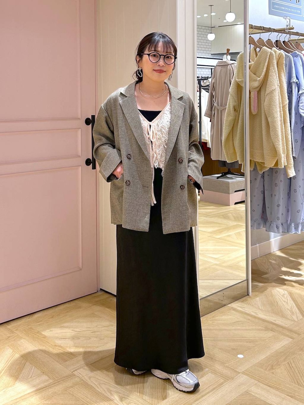 ブラック系のタンクトップ、ブラック系のスカート、ブラウン系のテーラードジャケットを着用したレディースの冬コーディネートの6枚目の写真