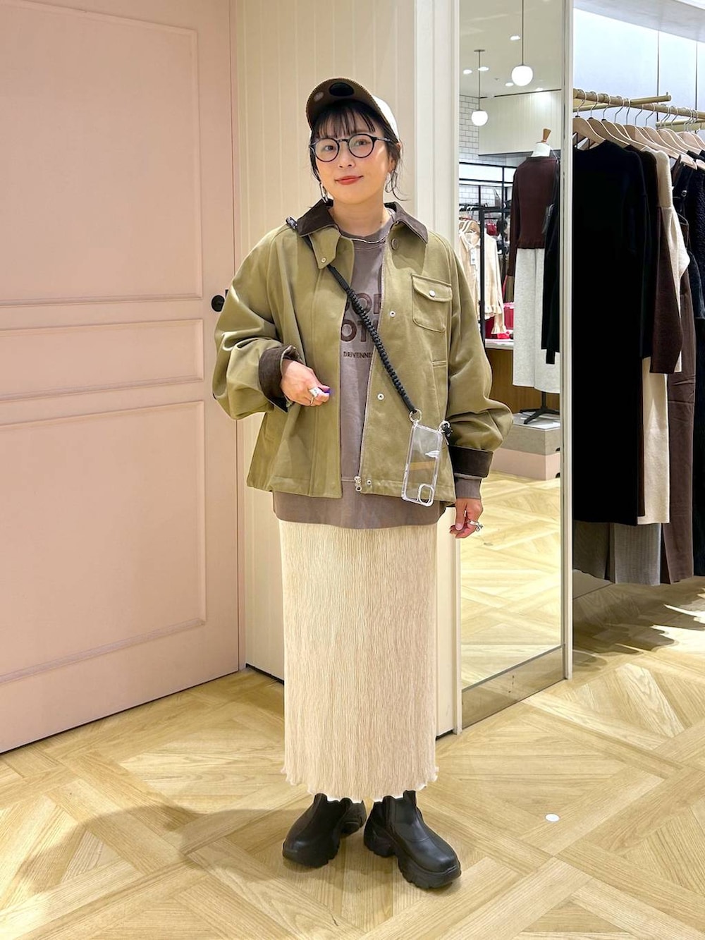 ブラック系のブーツ、ブラウン系のスウェット、ブラウン系のその他アウターを着用したレディースの秋コーディネートの2枚目の写真