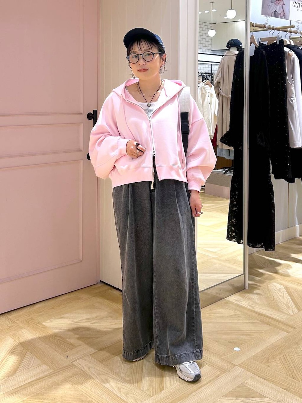 ピンク系のパーカー、ブラック系のデニムパンツ、グレー系のタンクトップを着用したレディースの春コーディネートの7枚目の写真