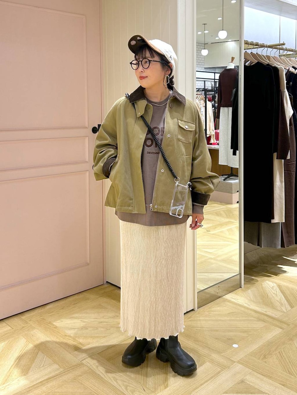 ブラック系のブーツ、ブラウン系のスウェット、ブラウン系のその他アウターを着用したレディースの秋コーディネートの3枚目の写真