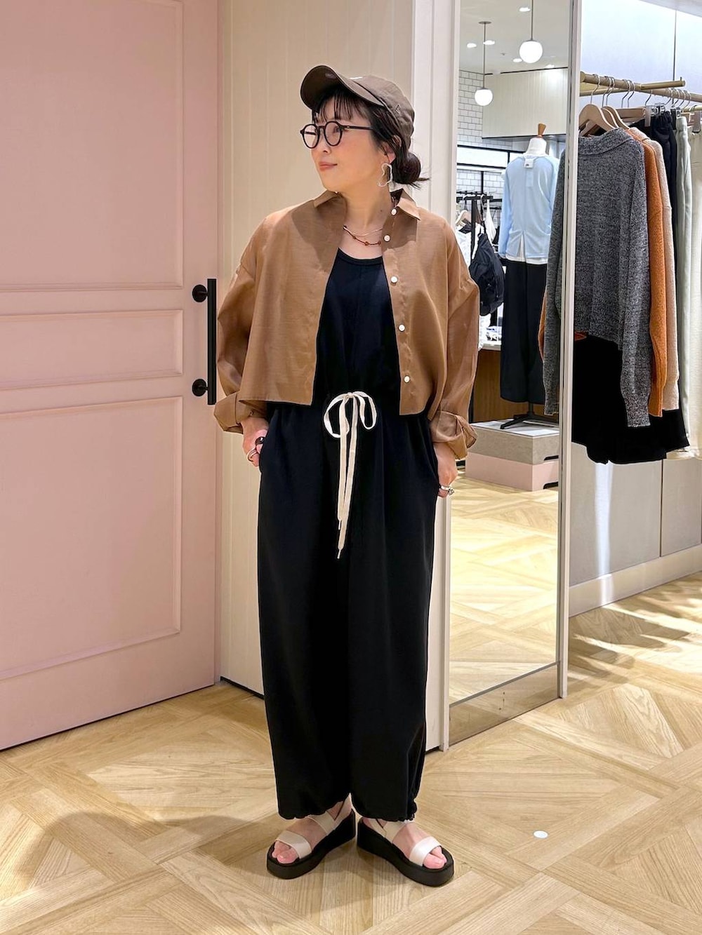 ブラウン系のシャツ/ブラウス、ホワイト系のサンダル、ブラック系のサロペット/オーバーオールを着用したレディースの春コーディネートの7枚目の写真