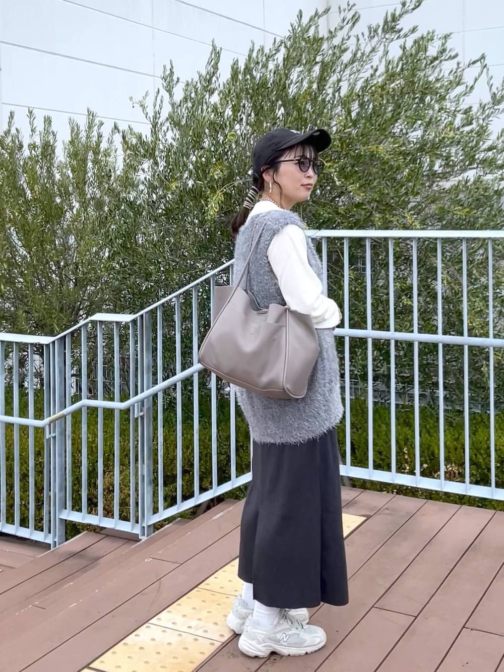 グレー系のスカート、グレー系のベスト、ホワイト系のTシャツ/カットソーを着用したレディースの秋コーディネートの3枚目の写真