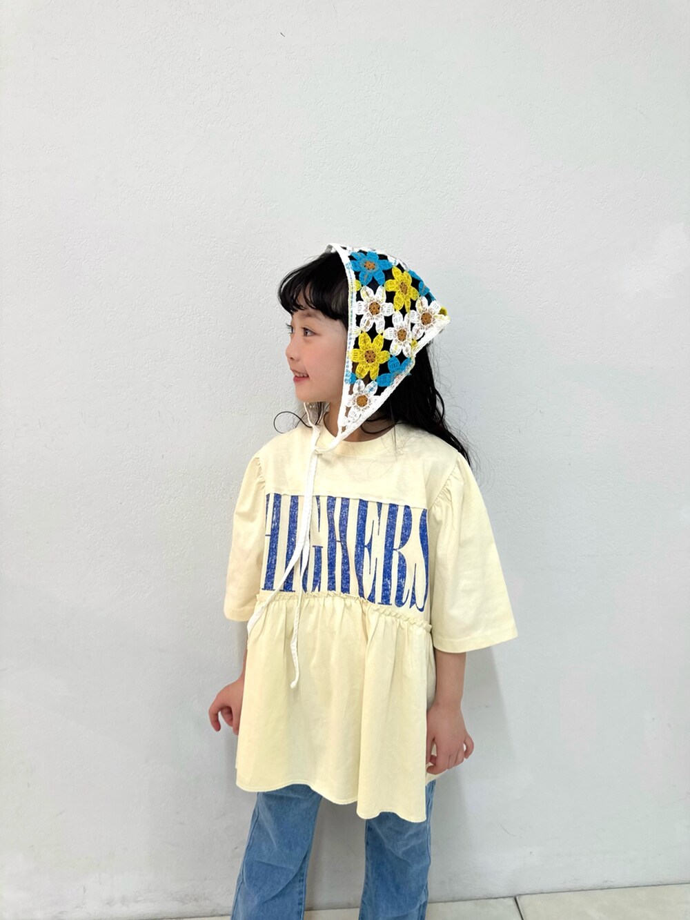 ブルー系のデニムパンツ、ホワイト系のワンピース、ホワイト系のバンダナ/スカーフを着用したキッズの春コーディネートの2枚目の写真