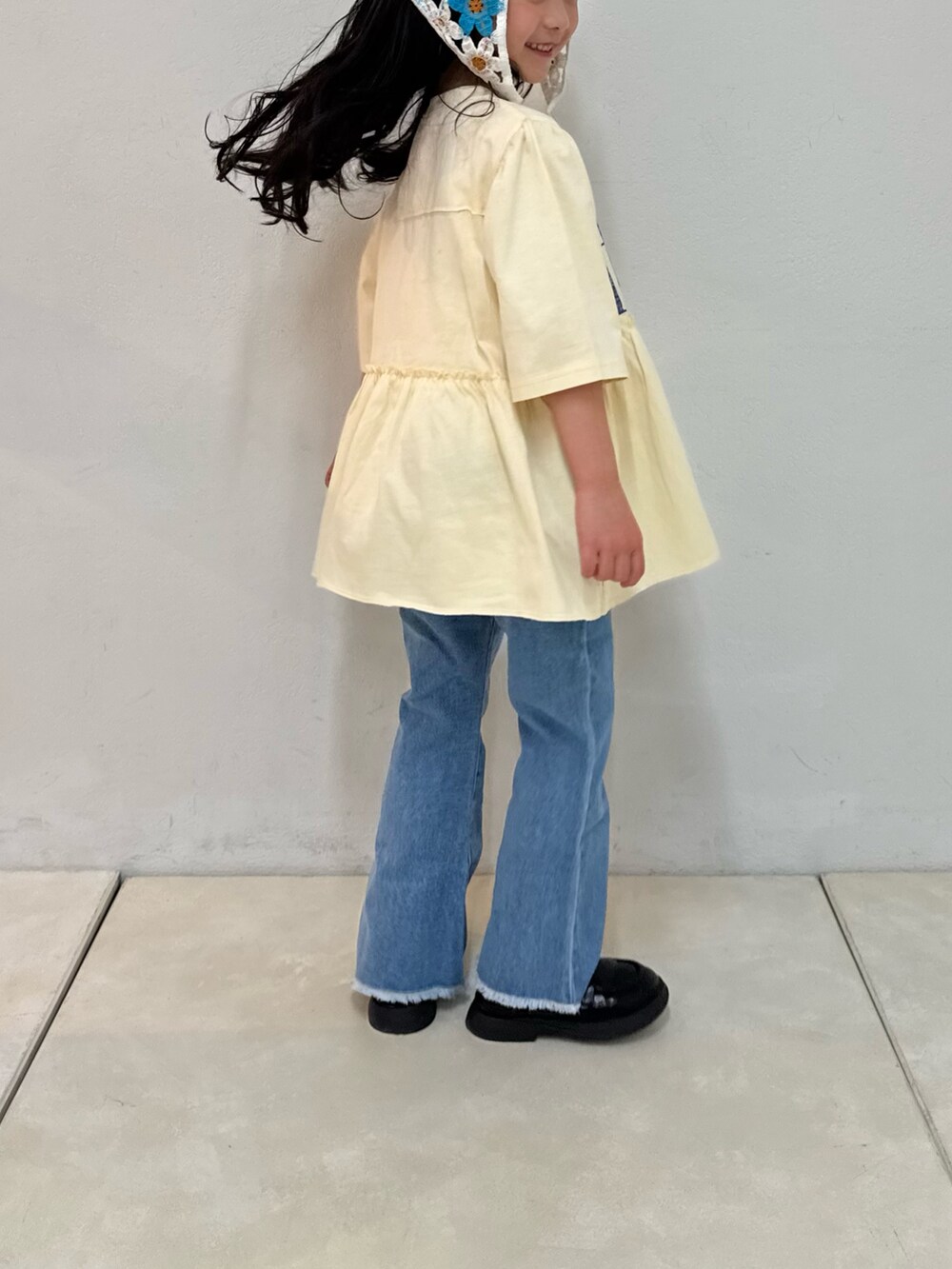 ブルー系のデニムパンツ、ホワイト系のワンピース、ホワイト系のバンダナ/スカーフを着用したキッズの春コーディネートの6枚目の写真