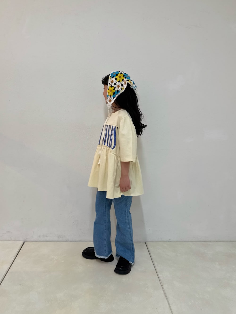 ブルー系のデニムパンツ、ホワイト系のワンピース、ホワイト系のバンダナ/スカーフを着用したキッズの春コーディネートの5枚目の写真