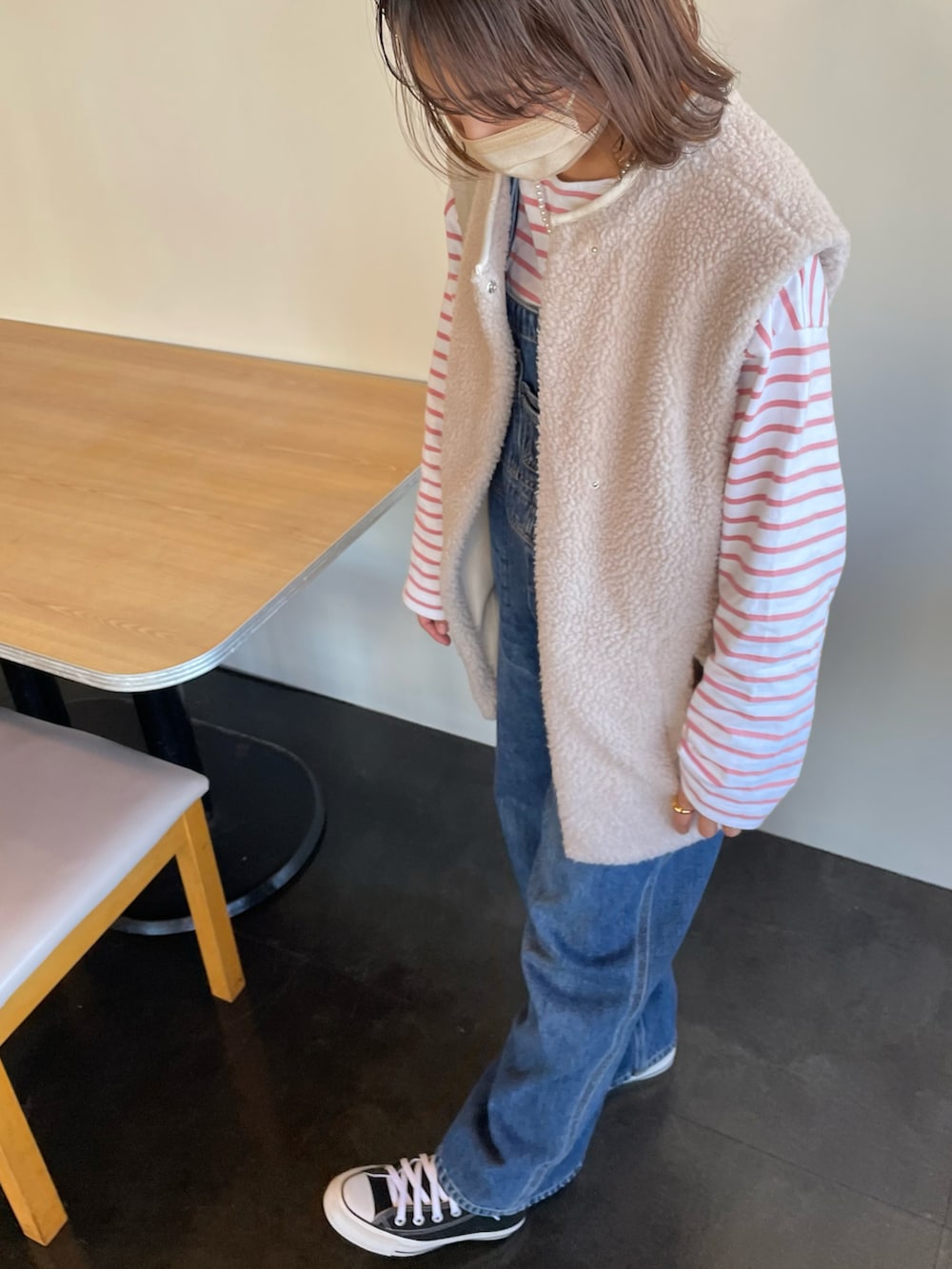 ブルー系のサロペット/オーバーオール、ブラック系のスニーカー、ピンク系のTシャツ/カットソーを着用したレディースの冬コーディネートの2枚目の写真