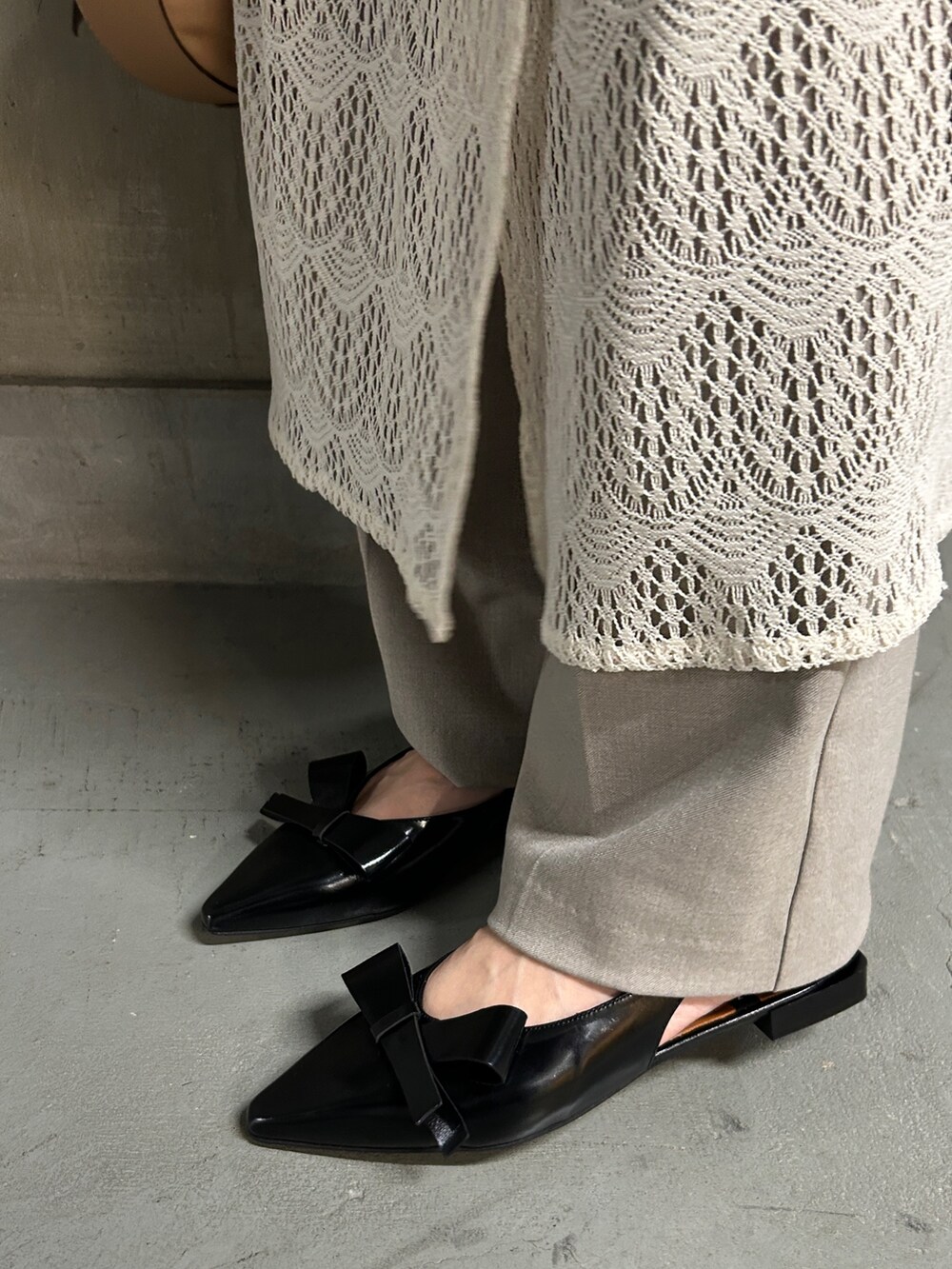 ホワイト系のTシャツ/カットソー、ベージュ系のハンドバッグ、ブラック系のパンプスを着用したレディースの春コーディネートの3枚目の写真