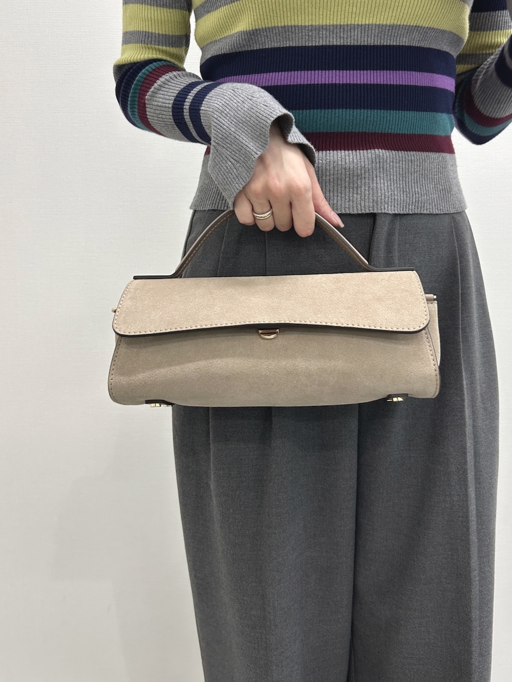 グレー系のハンドバッグ、グレー系のドレスシューズ、グレー系のニット/セーターを着用したレディースの冬コーディネートの3枚目の写真