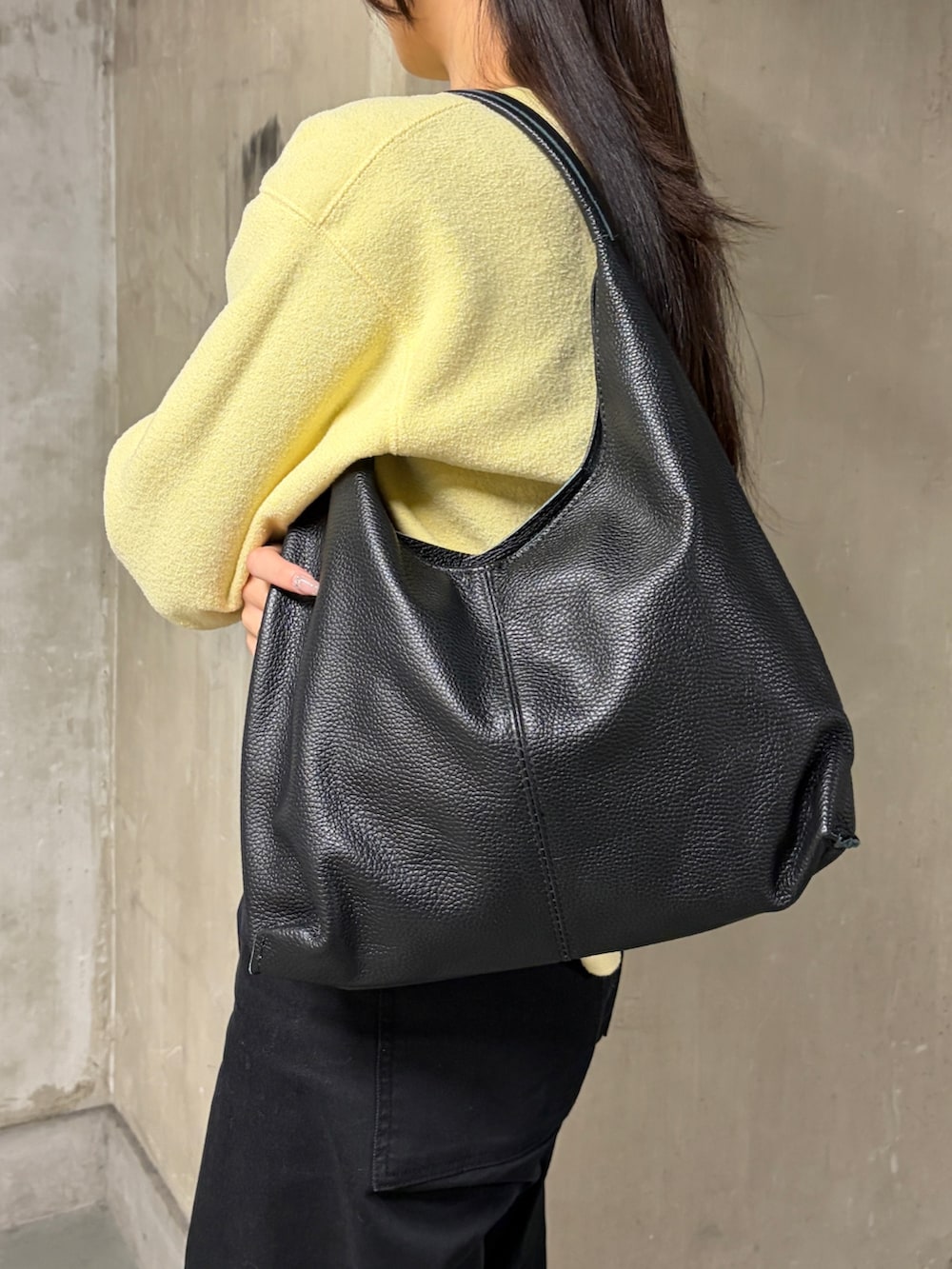 ブラック系のパンツ、ブラック系のローファー、ブラック系のショルダーバッグを着用したレディースの冬コーディネートの3枚目の写真