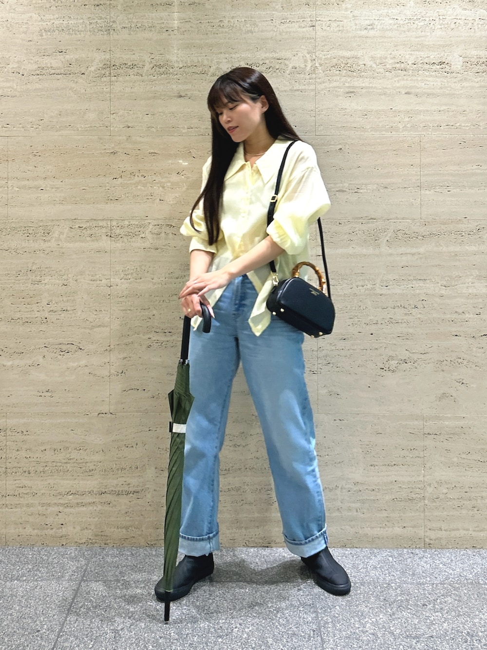 ブルー系のデニムパンツ、イエロー系のシャツ/ブラウス、ブラック系のスニーカーを着用したレディースの夏コーディネートの2枚目の写真