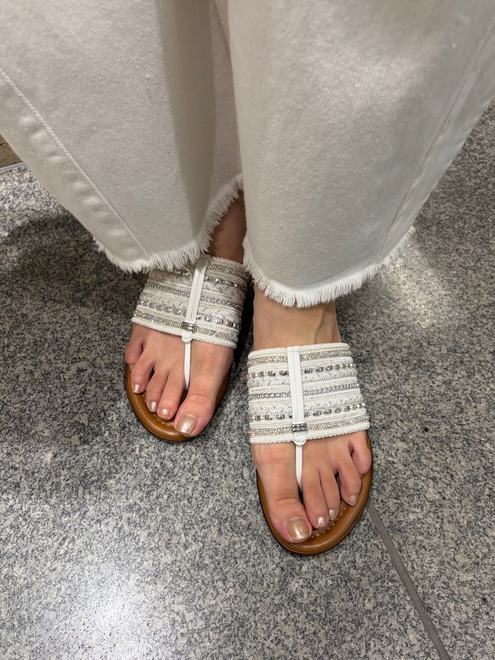 シルバー系のハンドバッグ、ブルー系のサンダル、グレー系のカーディガン/ボレロを着用したレディースの夏コーディネートの3枚目の写真