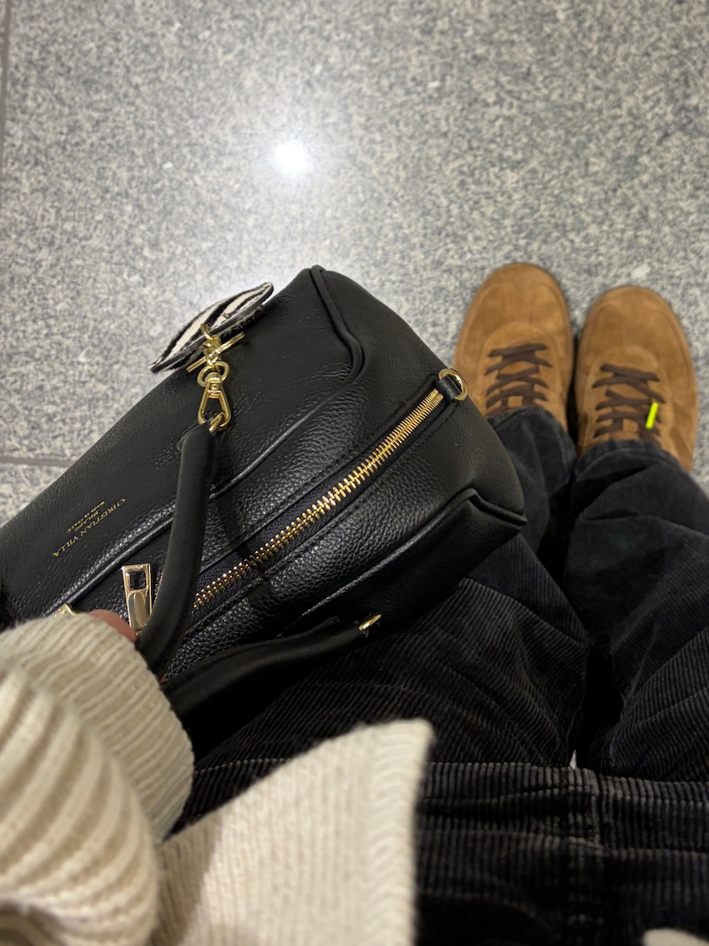 ブラック系のボストンバッグ、ブラック系のその他パンツ、ブラウン系のスニーカーを着用したレディースの冬コーディネートの2枚目の写真