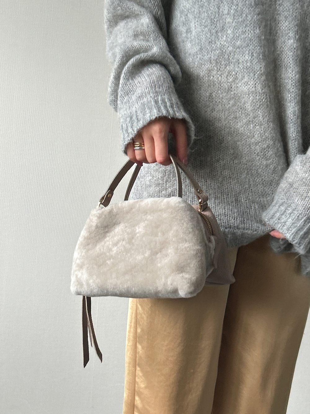 グレー系のニット/セーター、イエロー系のパンツ、ブラック系のパンプスを着用したレディースの秋コーディネートの2枚目の写真