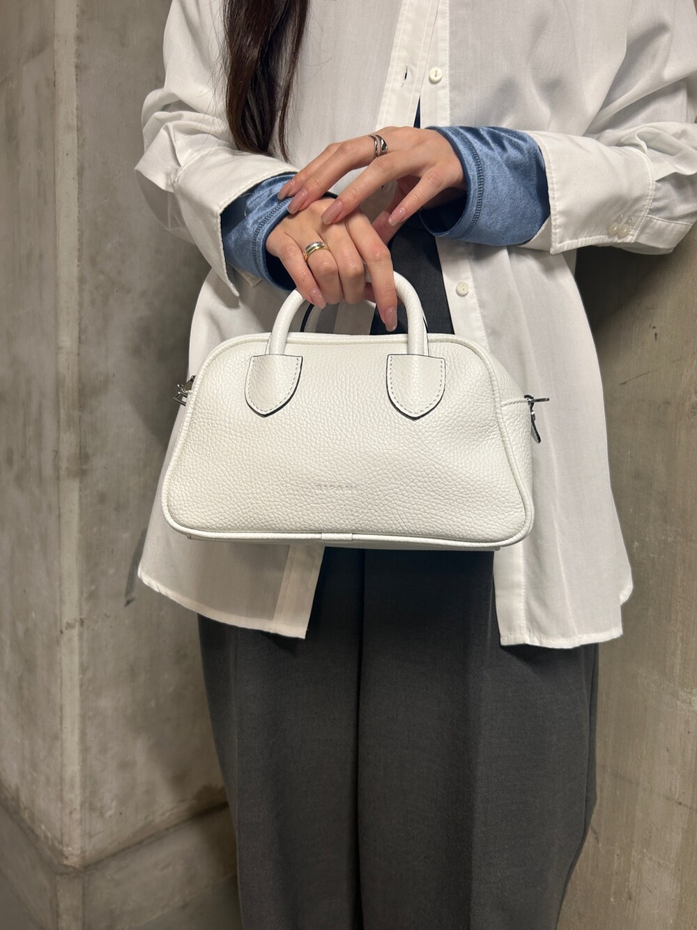ホワイト系のローファー、ホワイト系のボストンバッグ、ホワイト系のシャツ/ブラウスを着用したレディースの春コーディネートの2枚目の写真