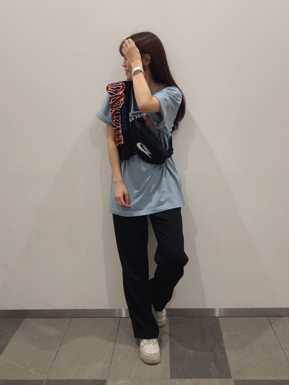 ホワイト系のスニーカー、ブラック系のスラックス、ブラック系のボディバッグ/ウエストポーチを着用したレディースの冬コーディネートの2枚目の写真