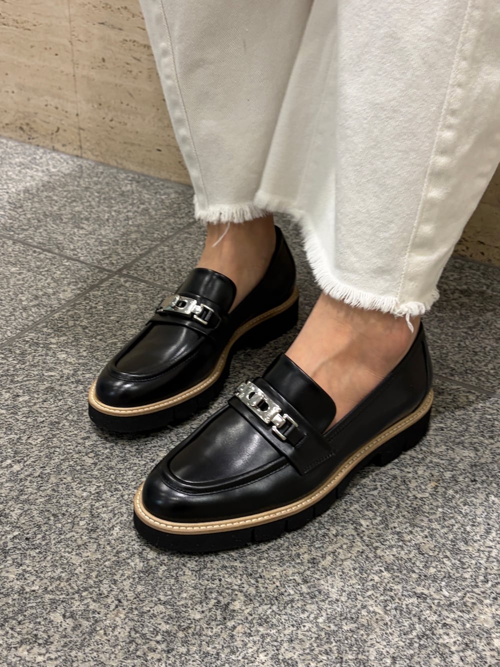 ブラウン系のトートバッグ、ブラック系のローファー、ブルー系のニット/セーターを着用したレディースの春コーディネートの4枚目の写真