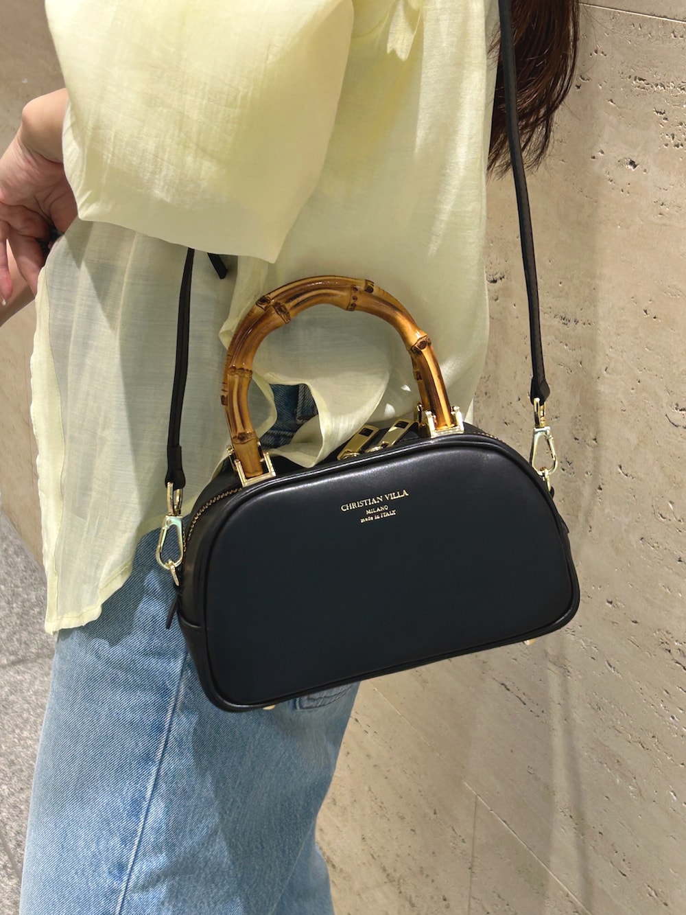 ブルー系のデニムパンツ、イエロー系のシャツ/ブラウス、ブラック系のスニーカーを着用したレディースの夏コーディネートの3枚目の写真