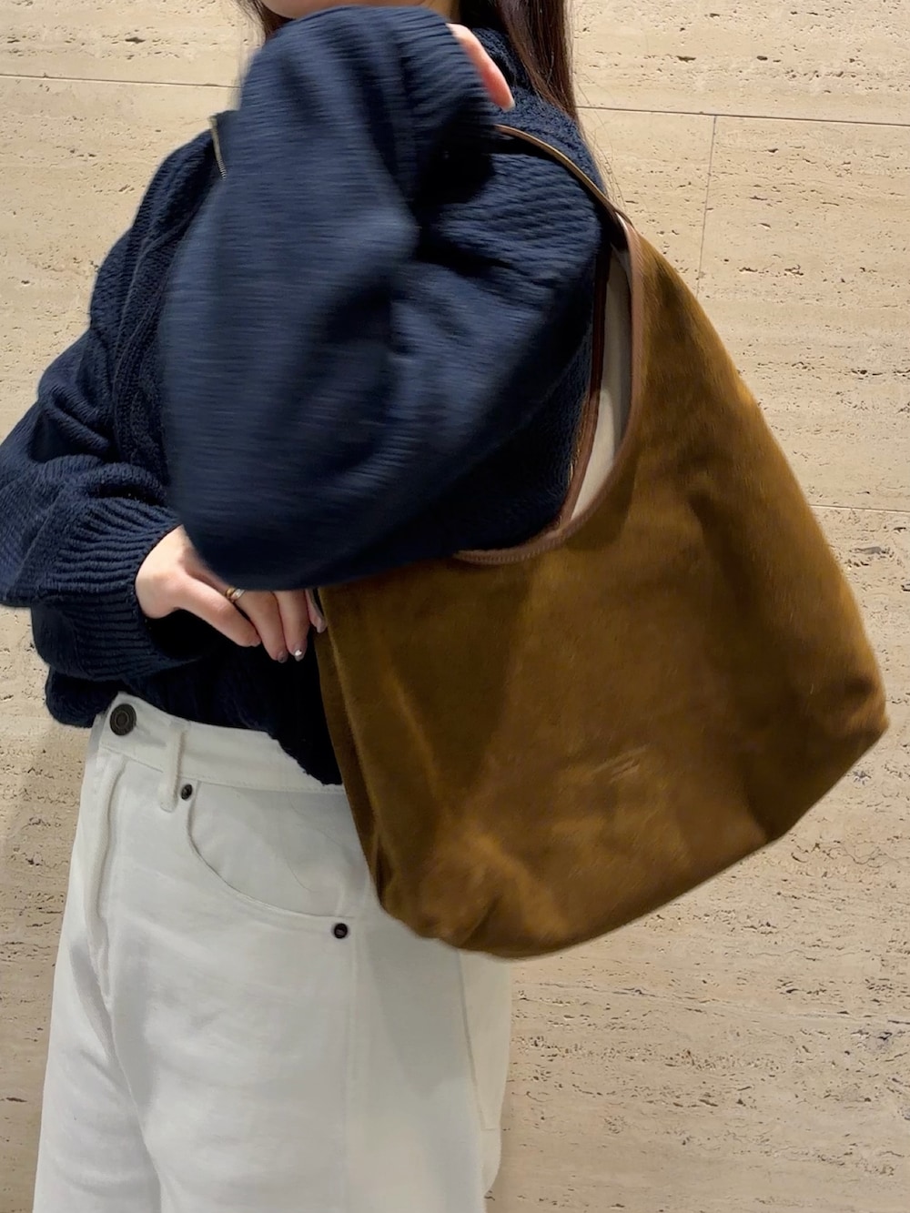 ブラウン系のトートバッグ、ブラック系のローファー、ブルー系のニット/セーターを着用したレディースの春コーディネートの3枚目の写真