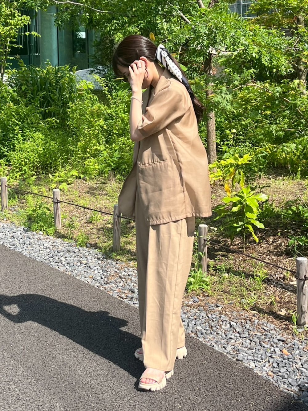 ベージュ系のかごバッグ、ベージュ系のテーラードジャケットを着用したレディースの春コーディネートの2枚目の写真