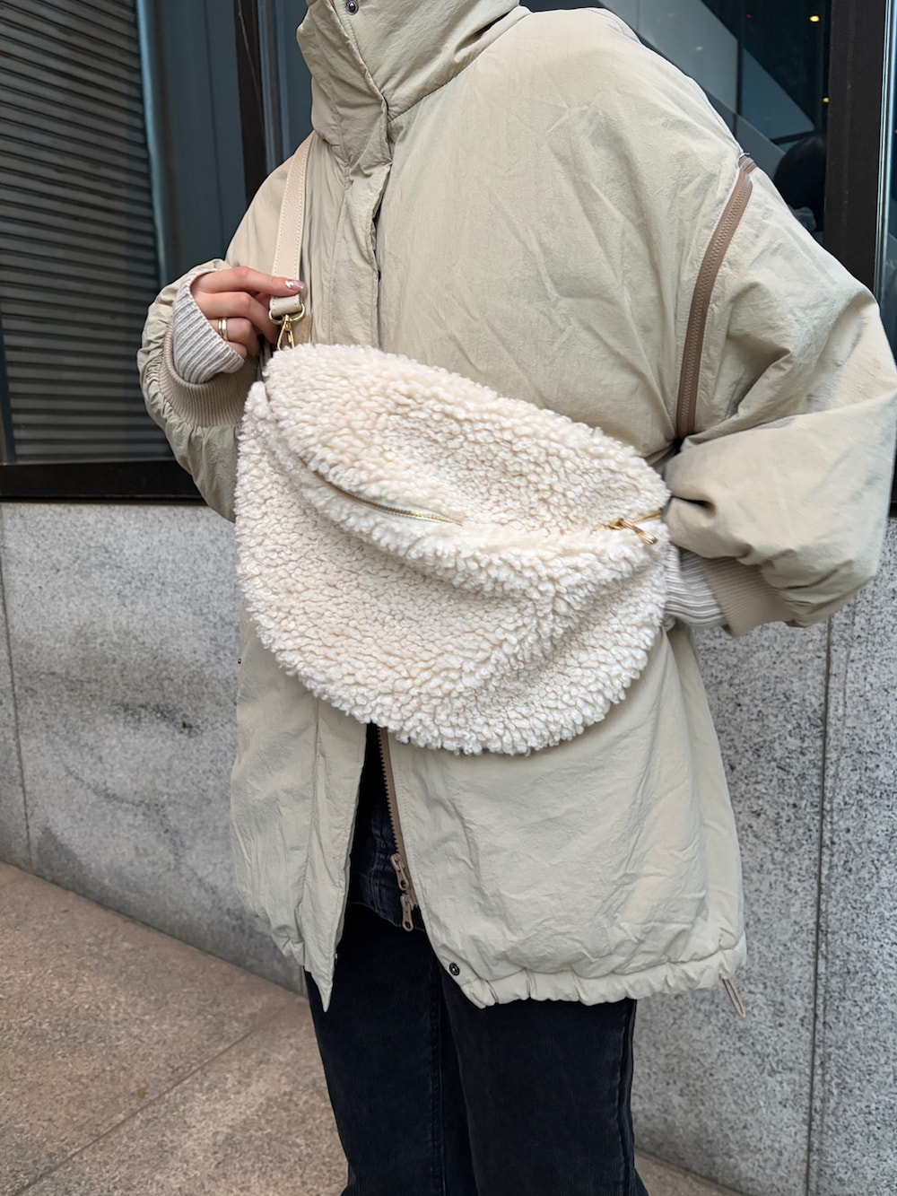 ベージュ系のナイロンジャケット、ブラック系のその他パンツ、ブラック系のブーツを着用したレディースの冬コーディネートの2枚目の写真