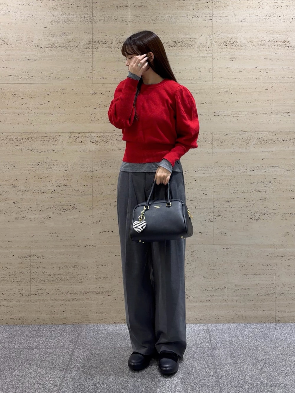 ブラック系のボストンバッグ、ブラック系のブーツ、ブラック系のキーホルダーを着用したレディースの冬コーディネートの2枚目の写真