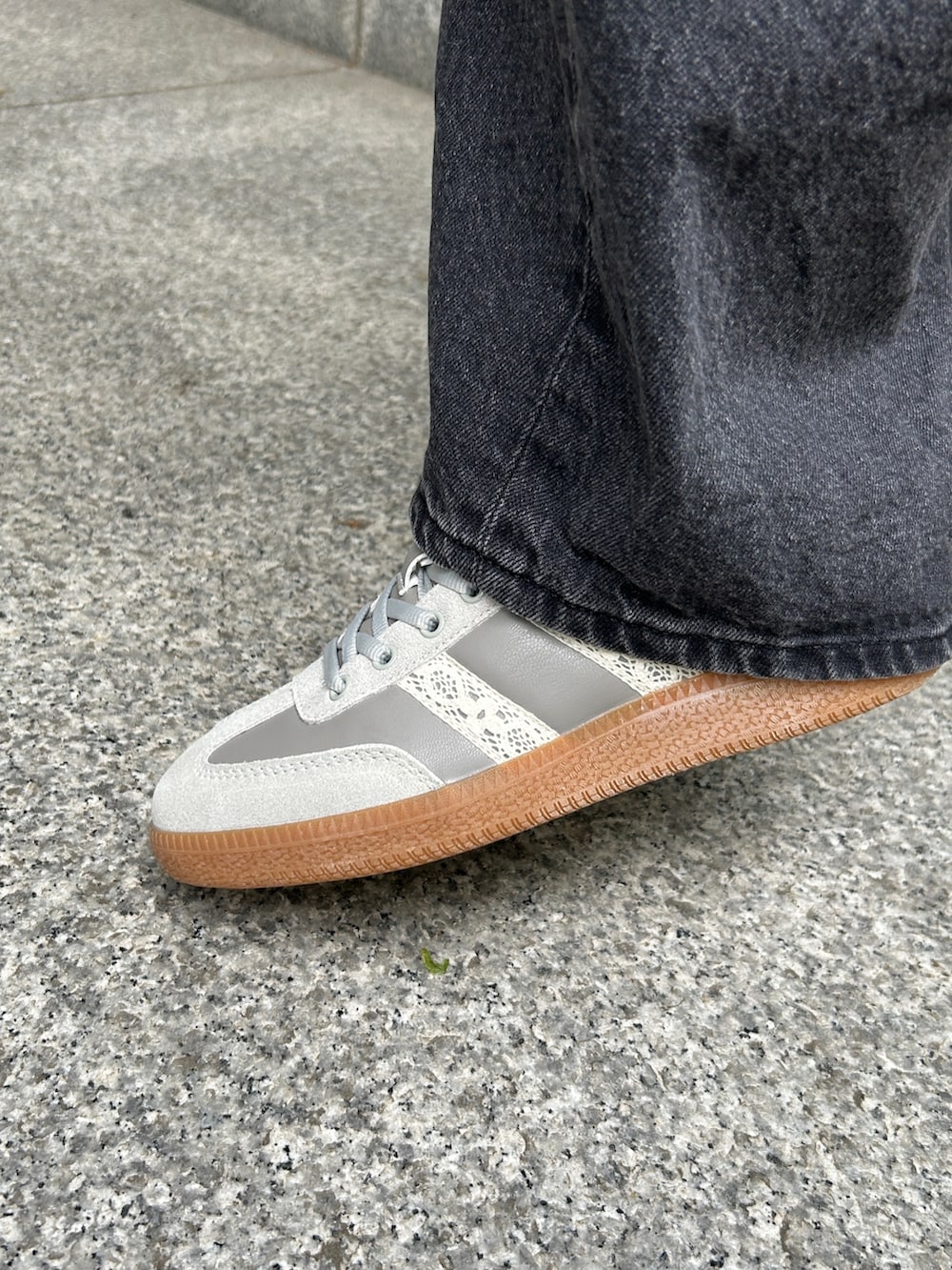 ブラック系のショルダーバッグ、グレー系のスニーカー、ブルー系のTシャツ/カットソーを着用したレディースの春コーディネートの2枚目の写真