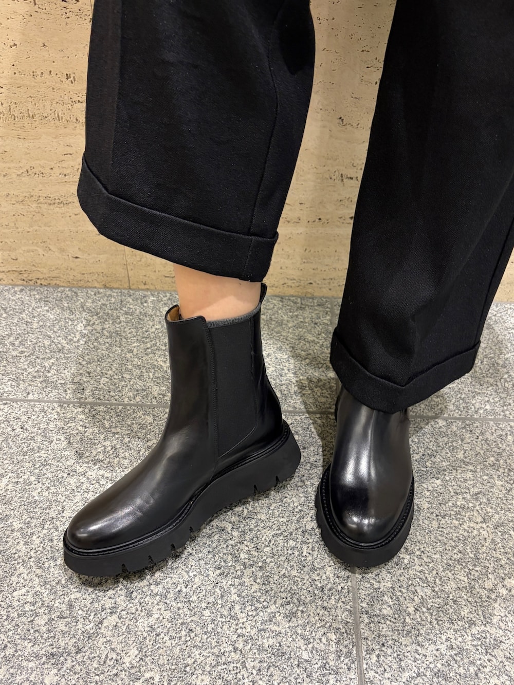 ブラック系のニット/セーター、ベージュ系のハンドバッグ、ブラック系のブーツを着用したレディースの冬コーディネートの4枚目の写真