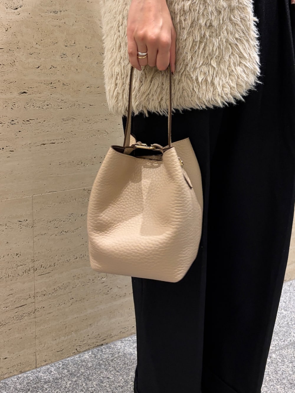 ブラック系のニット/セーター、ベージュ系のハンドバッグ、ブラック系のブーツを着用したレディースの冬コーディネートの3枚目の写真