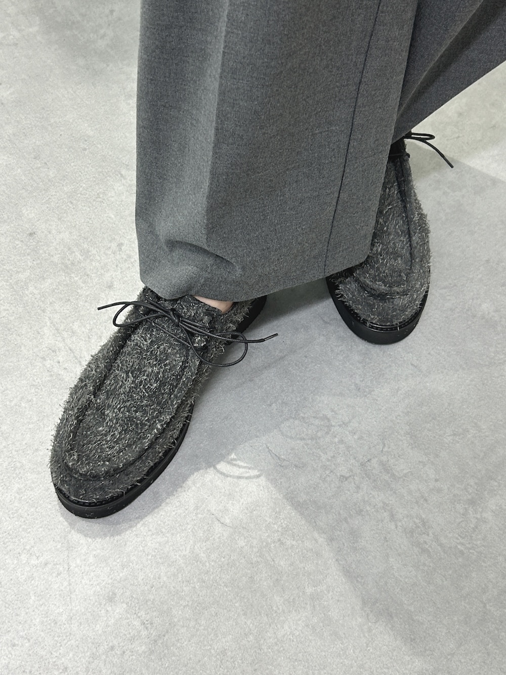 グレー系のハンドバッグ、グレー系のドレスシューズ、グレー系のニット/セーターを着用したレディースの冬コーディネートの2枚目の写真