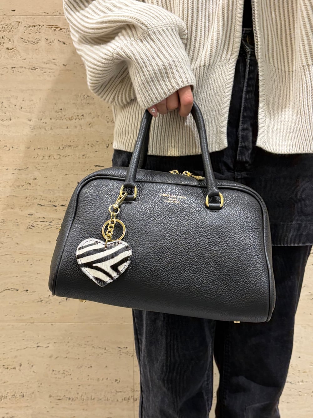 ブラック系のボストンバッグ、ブラック系のその他パンツ、ブラウン系のスニーカーを着用したレディースの冬コーディネートの4枚目の写真