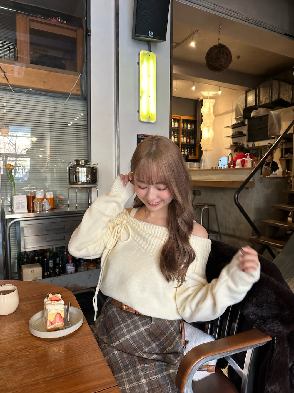 ホワイト系のニット/セーター、ホワイト系のショルダーバッグ、ブラウン系のスカートを着用したレディースの冬コーディネートの3枚目の写真