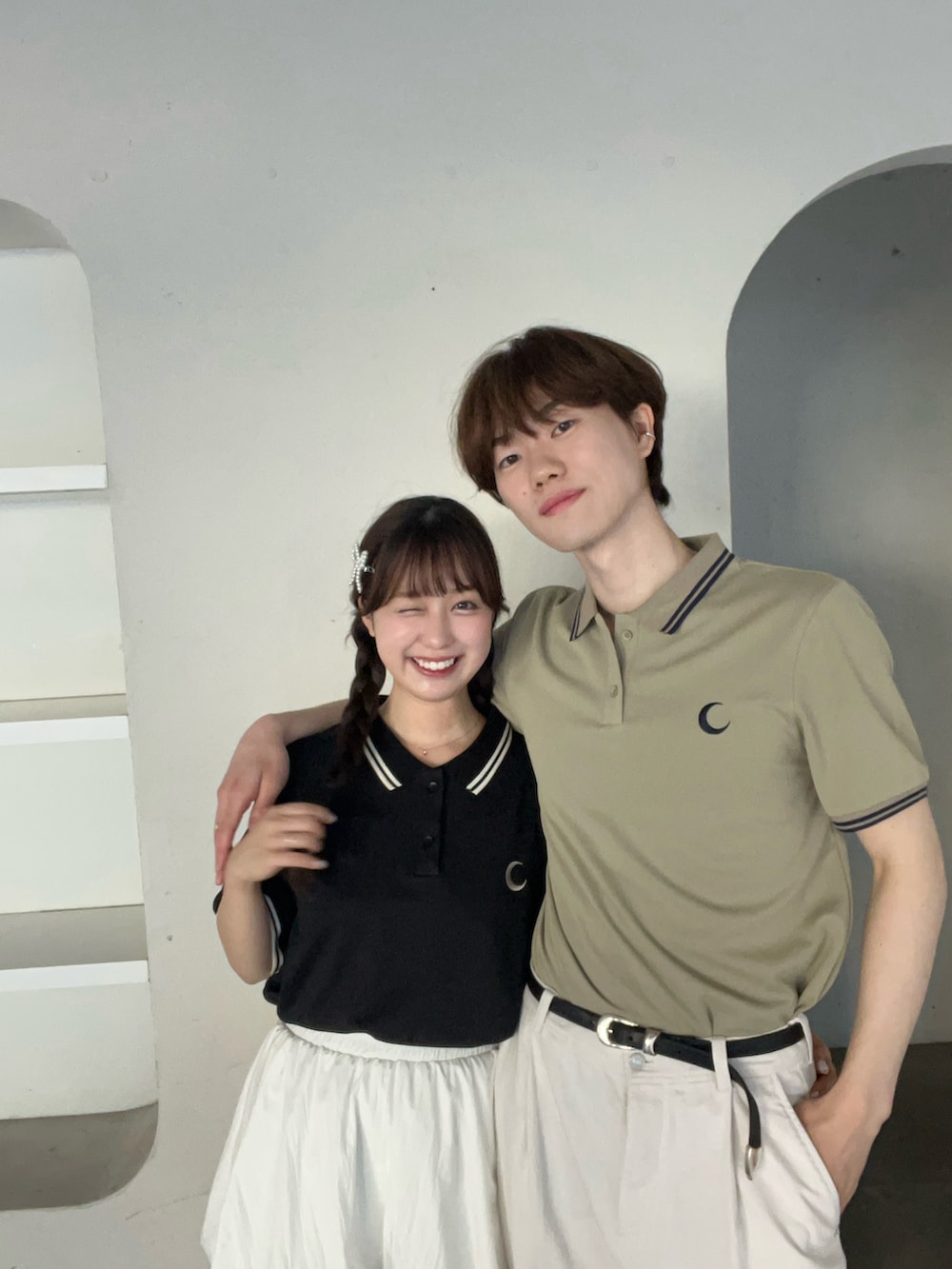 グリーン系のポロシャツ、ブラック系のポロシャツ、ホワイト系のスカートを着用したレディースの夏コーディネートの3枚目の写真