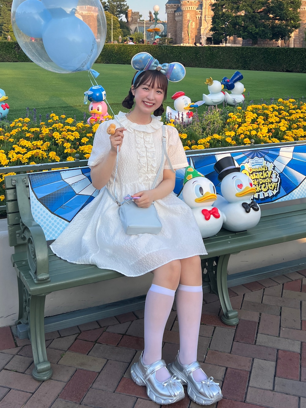 ホワイト系のワンピース、シルバー系のバレエシューズ、ブルー系のショルダーバッグを着用したレディースの夏コーディネートの2枚目の写真