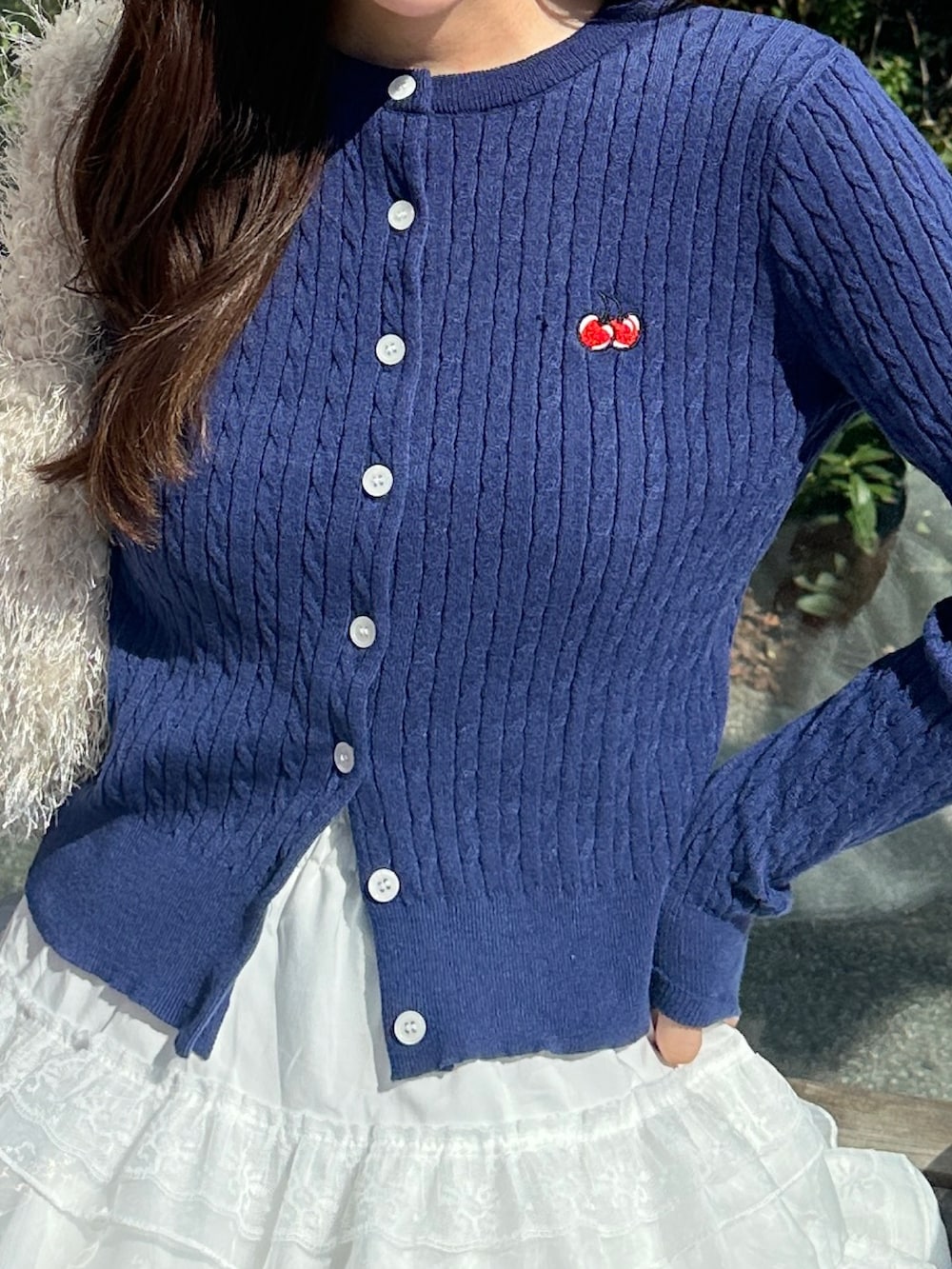 ブルー系のカーディガン/ボレロ、ホワイト系のスカート、ベージュ系のバッグを着用したレディースの夏コーディネートの3枚目の写真