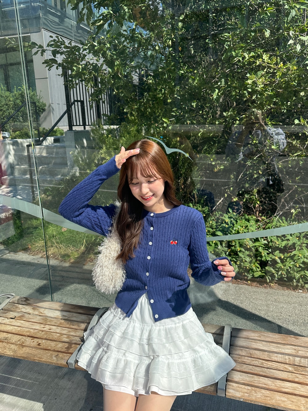 ブルー系のカーディガン/ボレロ、ホワイト系のスカート、ベージュ系のバッグを着用したレディースの夏コーディネートの2枚目の写真