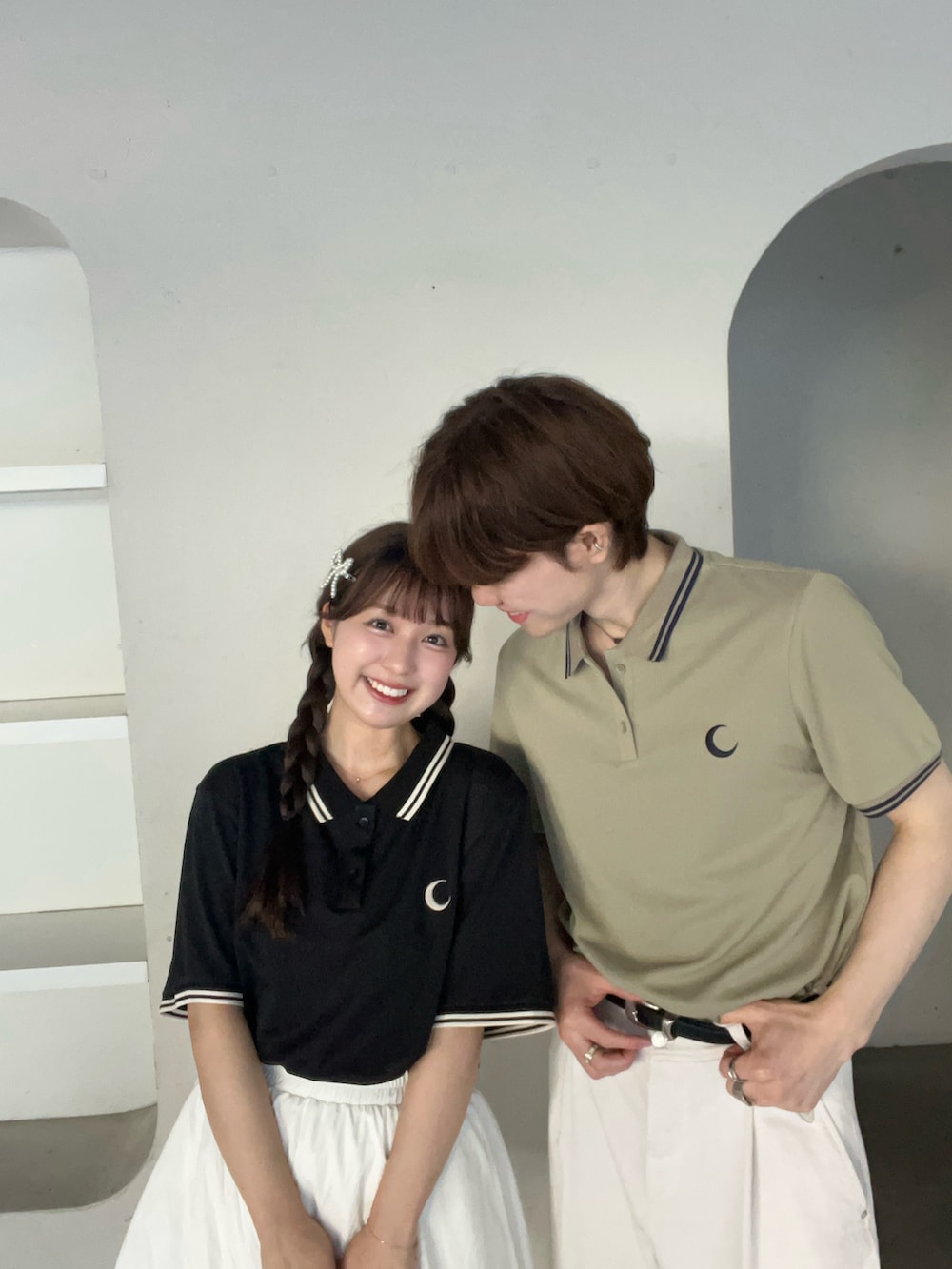 グリーン系のポロシャツ、ブラック系のポロシャツ、ホワイト系のスカートを着用したレディースの夏コーディネートの2枚目の写真