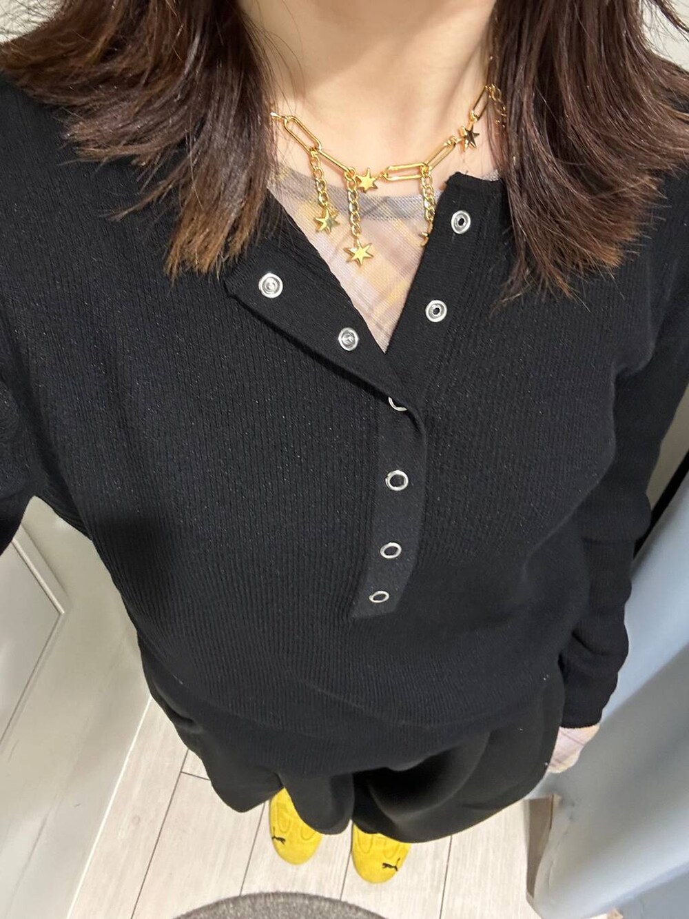 ブラック系のスウェットパンツ、ブラック系のニット/セーター、イエロー系のTシャツ/カットソーを着用したレディースの秋コーディネートの4枚目の写真