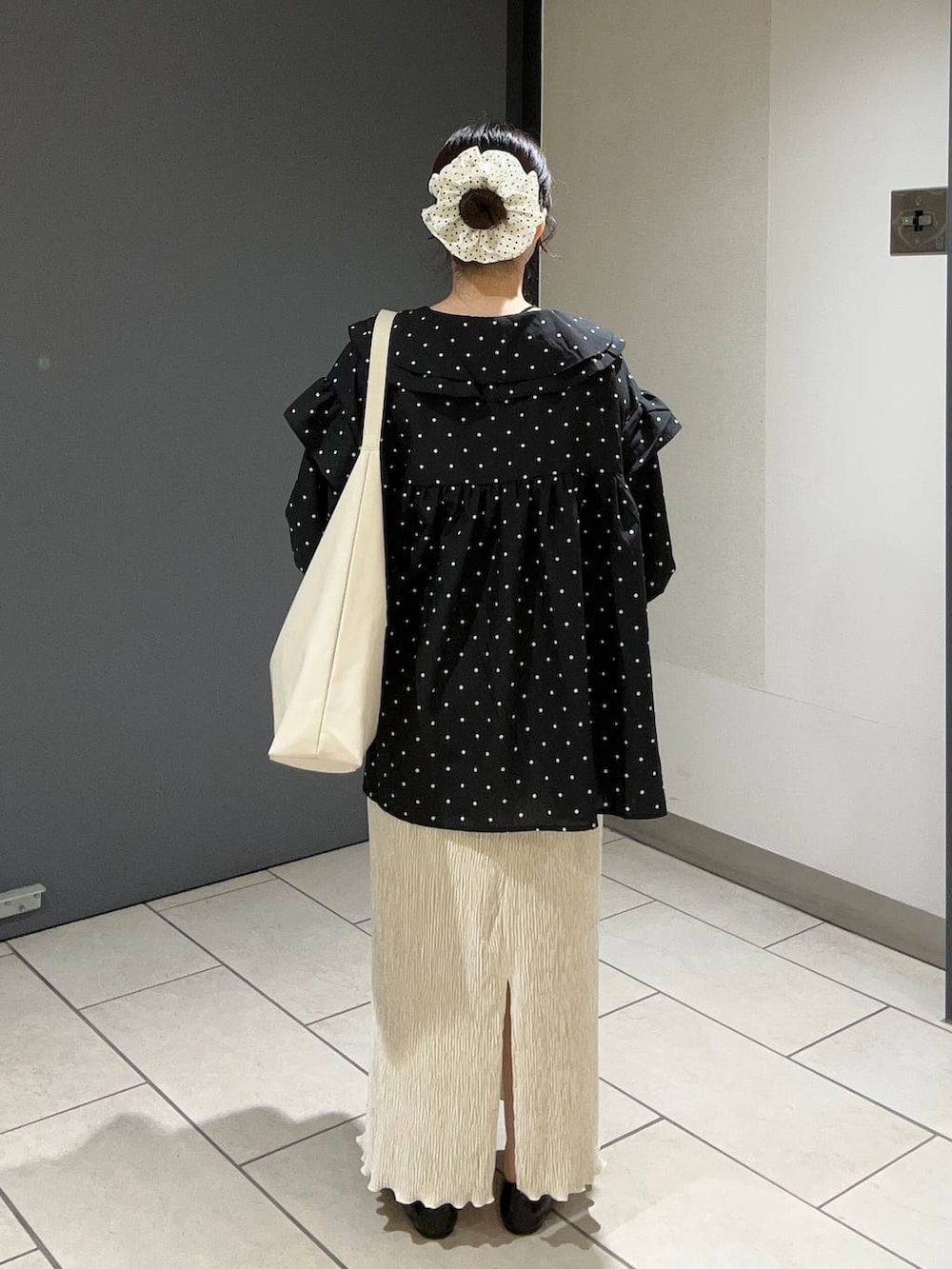 ホワイト系のショルダーバッグ、ブラック系のパンプス、ホワイト系のスカートを着用したレディースの秋コーディネートの3枚目の写真