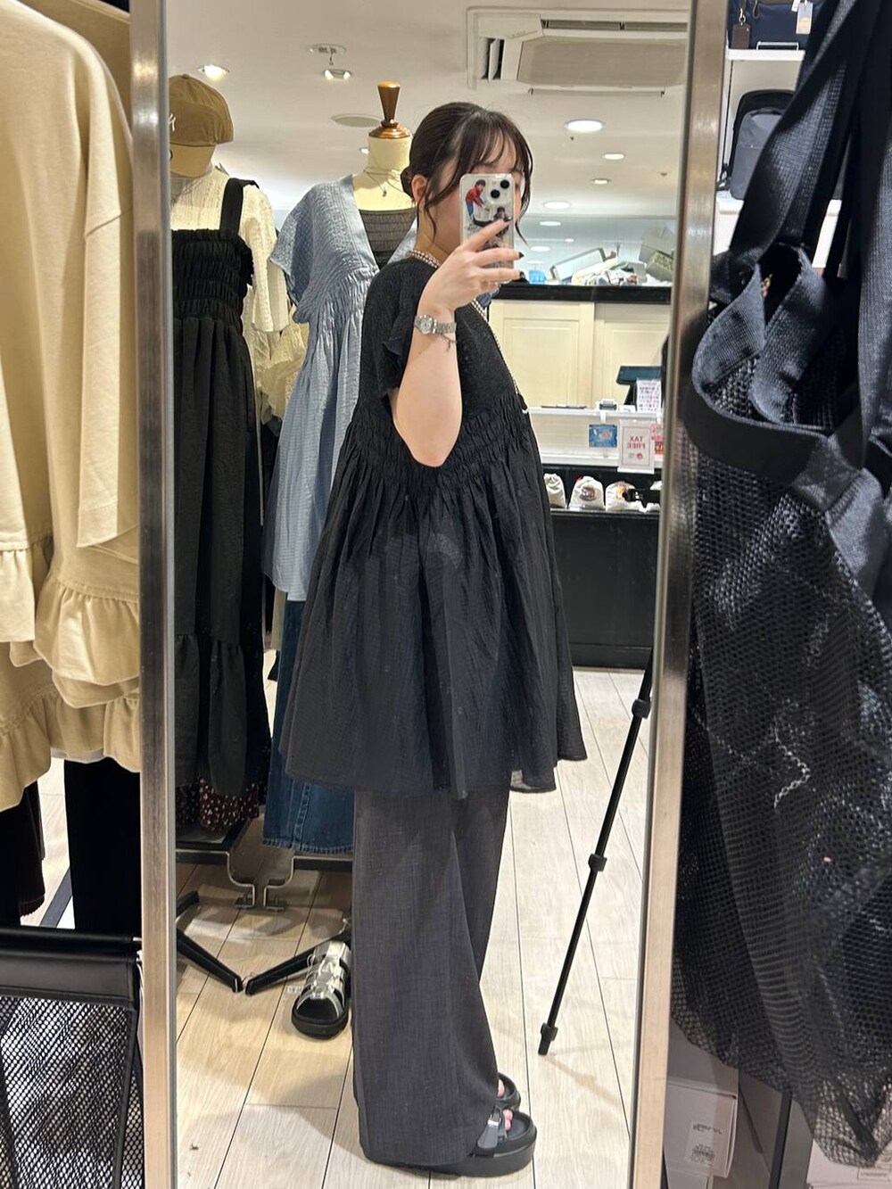 ホワイト系のTシャツ/カットソー、ブラウン系のサンダル、グレー系のスラックスを着用したレディースの夏コーディネートの2枚目の写真