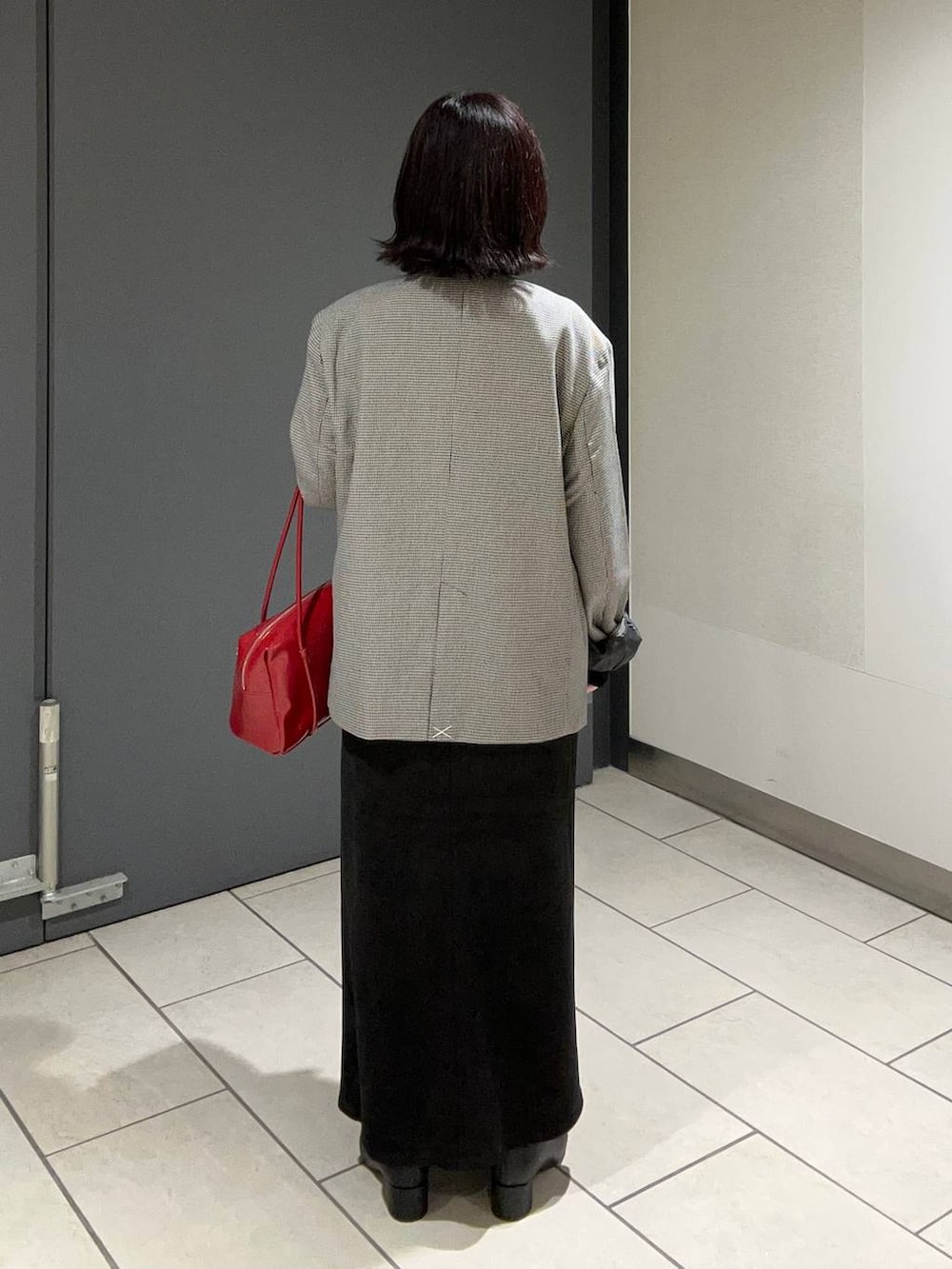 その他のテーラードジャケット、ブラック系のスカート、レッド系のボストンバッグを着用したレディースの秋コーディネートの3枚目の写真